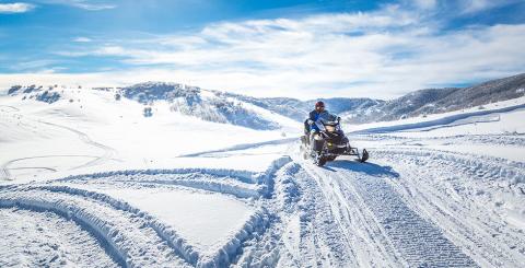 Un motoneigiste en pleine randonnée dans des montagnes enneigées